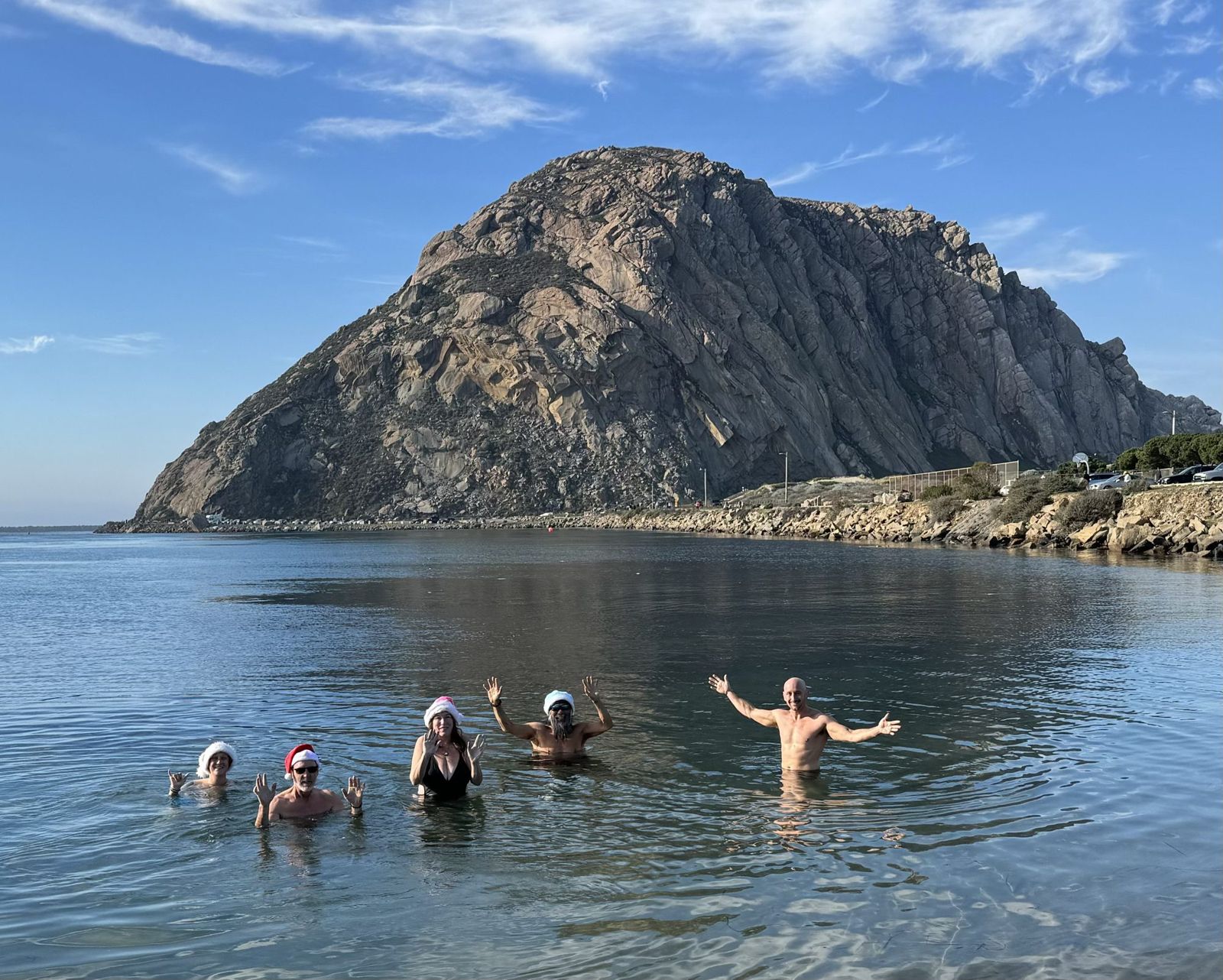 Christmas Day dip: odders in Santa hats waving from the water in front of Morro Rock